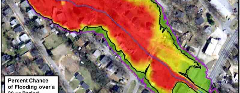 Computer generated flood analysis shows chance of flooding over a 30-year period overlaid on aerial photo of a city. A wide area of reds and oranges shading upstream of an encroachment of the valley i..., tags: schätzungen - CC BY-SA